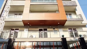 A multi-story building with balconies, a decorative gate, and a clear blue sky. - Covie Gurgaon 70 (Gurugram)