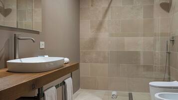 Une salle de bain moderne avec un grand lavabo, un miroir et un espace douche.