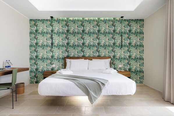 Una habitación de hotel moderna con una cama grande, un escritorio y un baño.