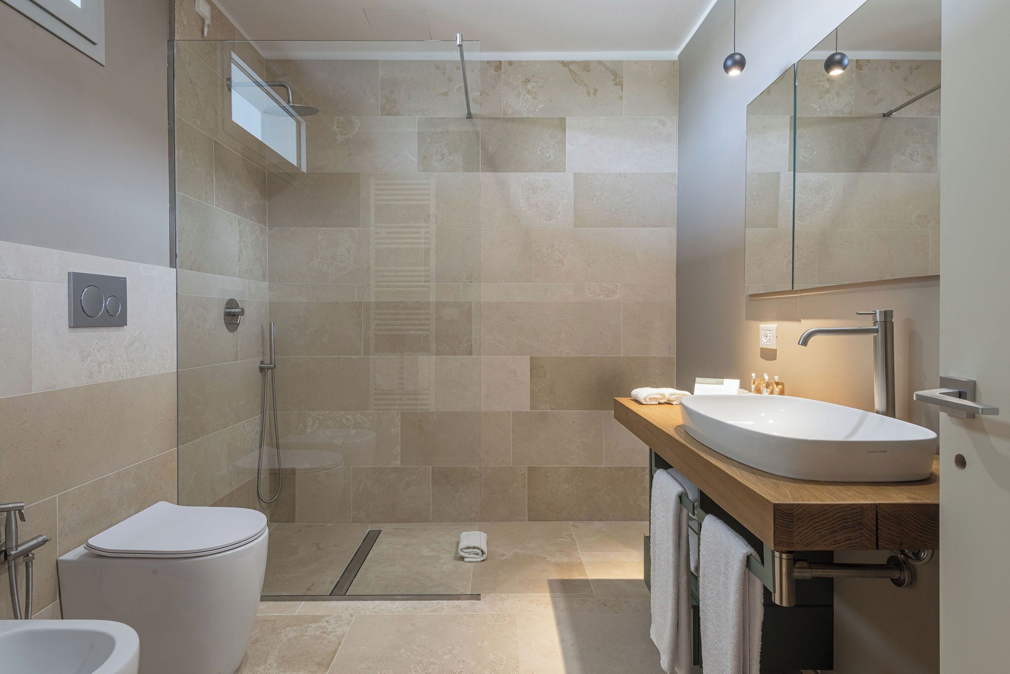 Un baño moderno con ducha, inodoro y lavamanos.