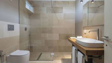 Un baño moderno con ducha, inodoro y lavamanos.