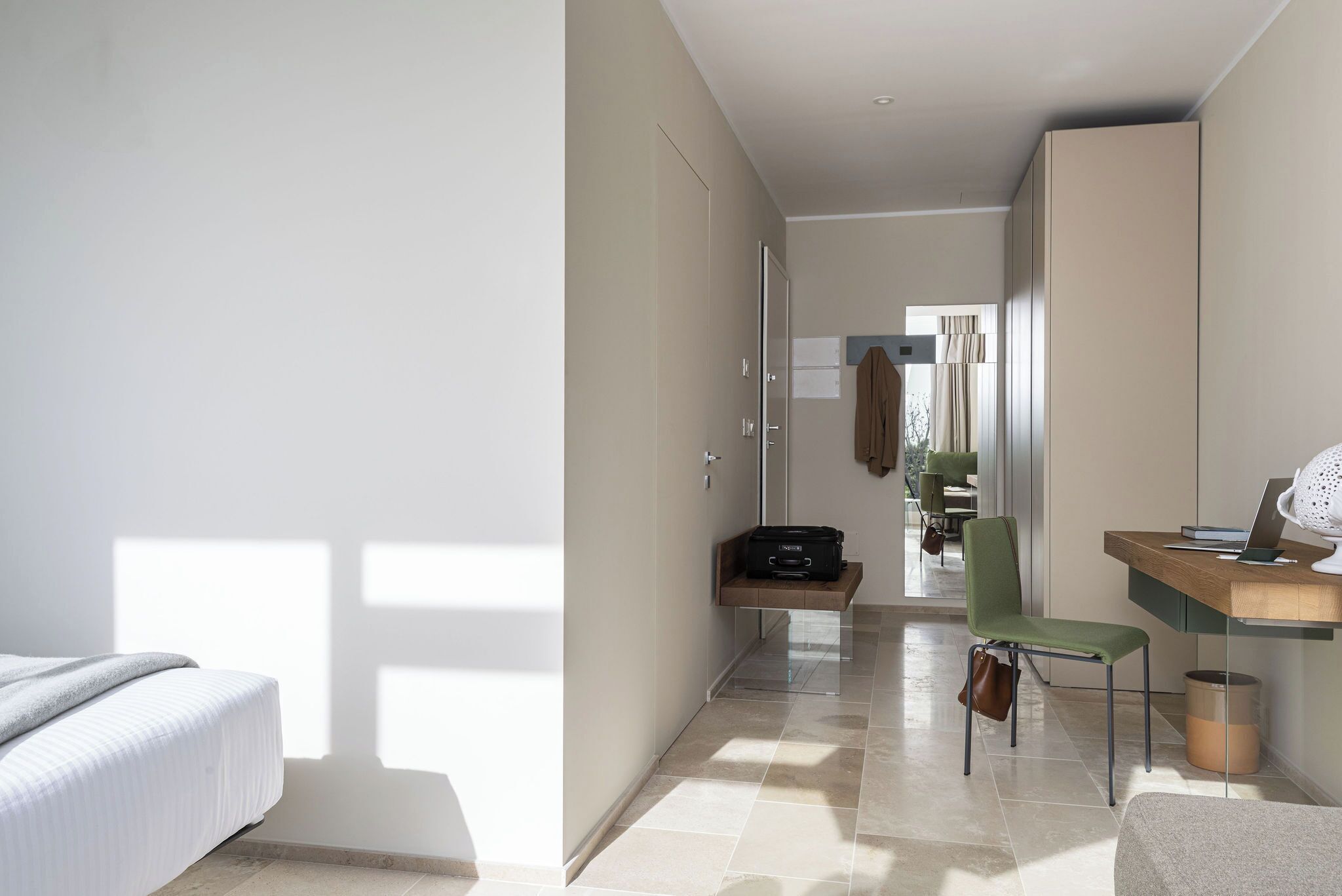 Une chambre d’hôtel moderne équipée d’un lit, d’un bureau, d’une chaise et d’une armoire.