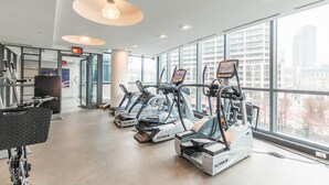 A gym with treadmills, a weight bench, and large windows offering a city view. - GLOBALSTAY. Bright 1Br+Den Unit in Downtown (Toronto/Canada)