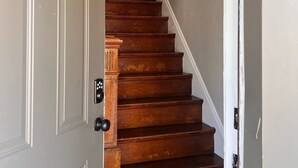 A wooden staircase with a white door marked with the number 2.