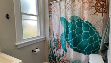 Bathtub, hair dryer, towels, shampoo