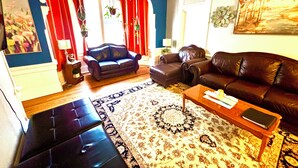 A living room with a sofa, a coffee table, and a patterned rug.