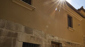 Un bâtiment doté d’une façade en pierre, d’une porte en bois et d’une fenêtre.