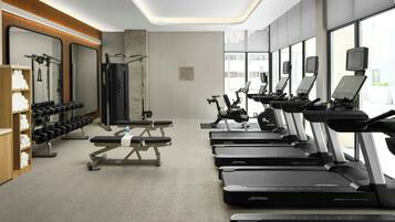 A modern gym with treadmills, dumbbells, and weight machines.