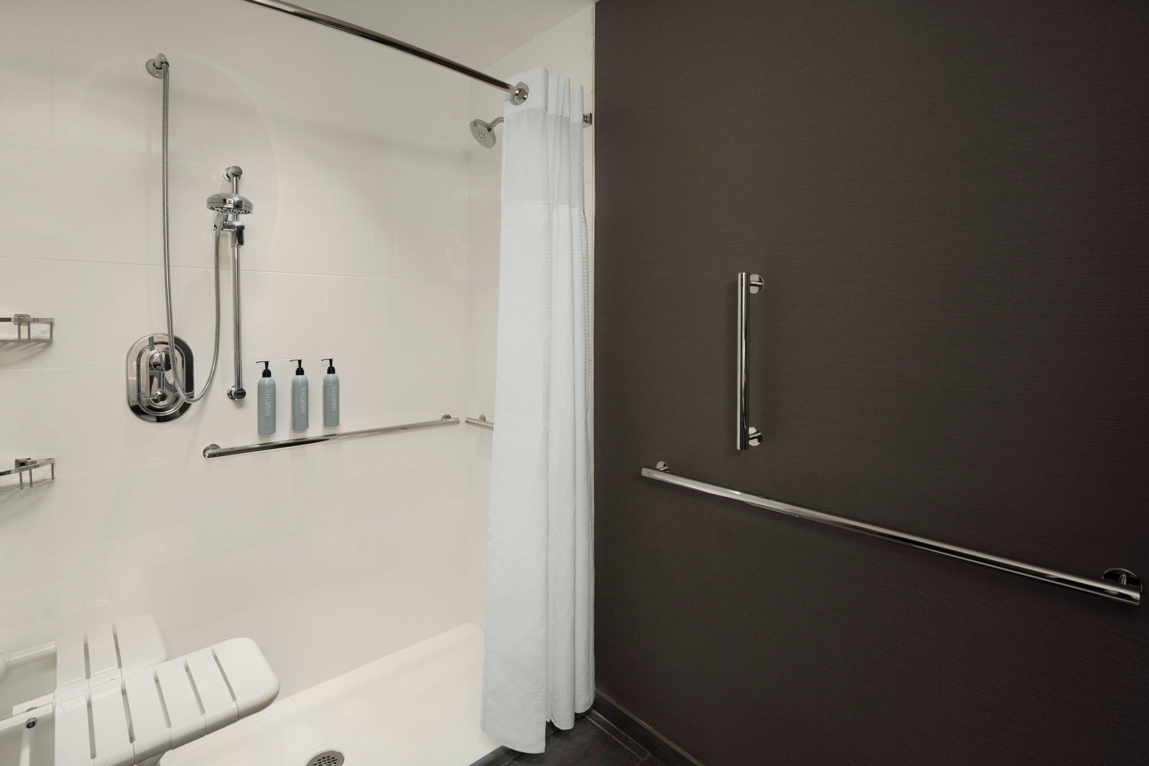 A modern bathroom with a shower, a toilet, and a bathtub.