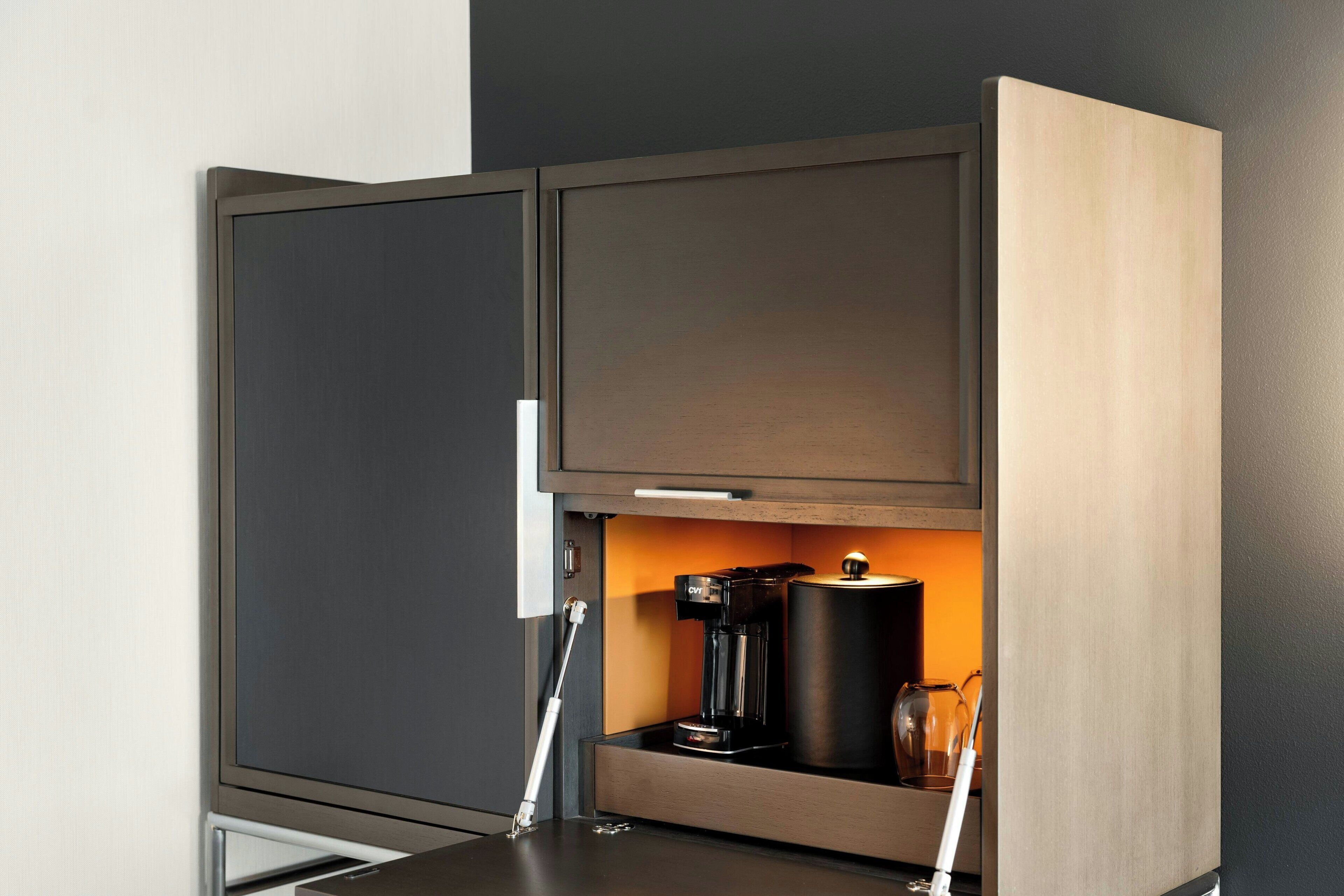 Een moderne keuken met een ingebouwde koffiezetapparaat en een glazen pot.