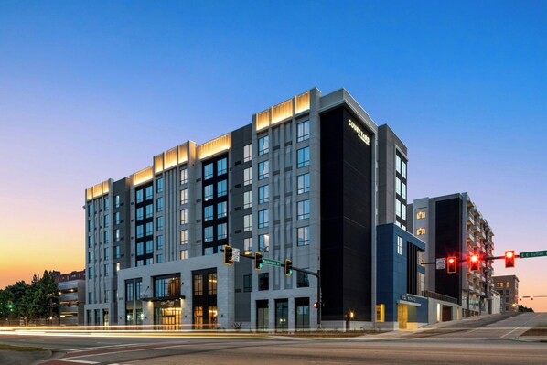A modern hotel with a prominent entrance, multiple floors, and a clear view of the street at dusk. - Courtyard by Marriott Gainesville GA (Gainesville)