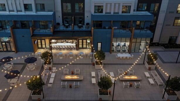 A courtyard with outdoor seating, a central fire feature, and a restaurant area. - Courtyard by Marriott Gainesville GA (Gainesville)