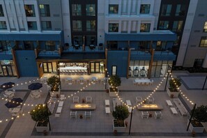 A courtyard with outdoor seating, a central fire feature, and a restaurant area. - Courtyard by Marriott Gainesville GA (Gainesville)