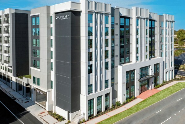 A modern hotel building with a prominent 'Courtyard by Marriott' sign, multiple floors, and a parking lot in front. - Courtyard by Marriott Gainesville GA (Gainesville)