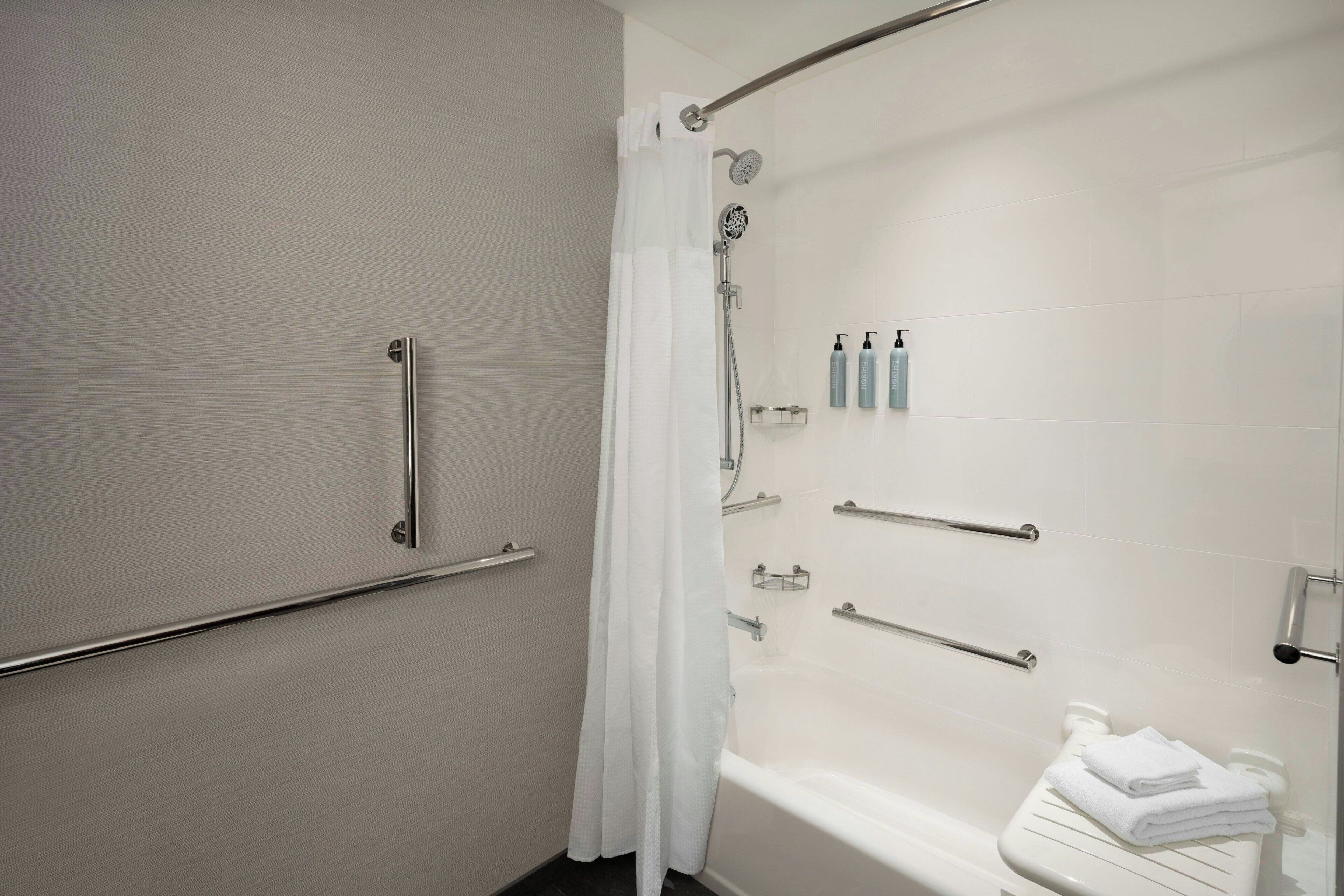 A bathroom with a shower, a toilet, and a towel rack.