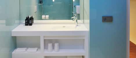A modern bathroom with a glass shower enclosure, a white sink, and a mirror.