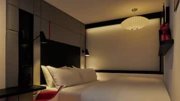 Una habitación de hotel moderna con una cama, un escritorio y una silla.