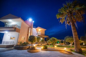 Set amidst lush gardens, this two-story building features a spacious balcony and a flat roof.