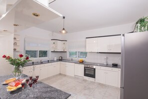 Enjoy cooking in this well-equipped kitchen with an oven, sink, and stainless steel refrigerator.