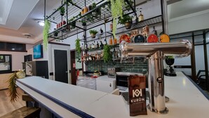 A bar area with a metal shelf holding various bottles and a tap labeled 'KURUN'. - Hotel Asturias (Vina del Mar)