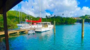 Ein Yachthafen mit vertäuten Booten, ein hölzerner Steg und ein klarer, blauer Himmel.