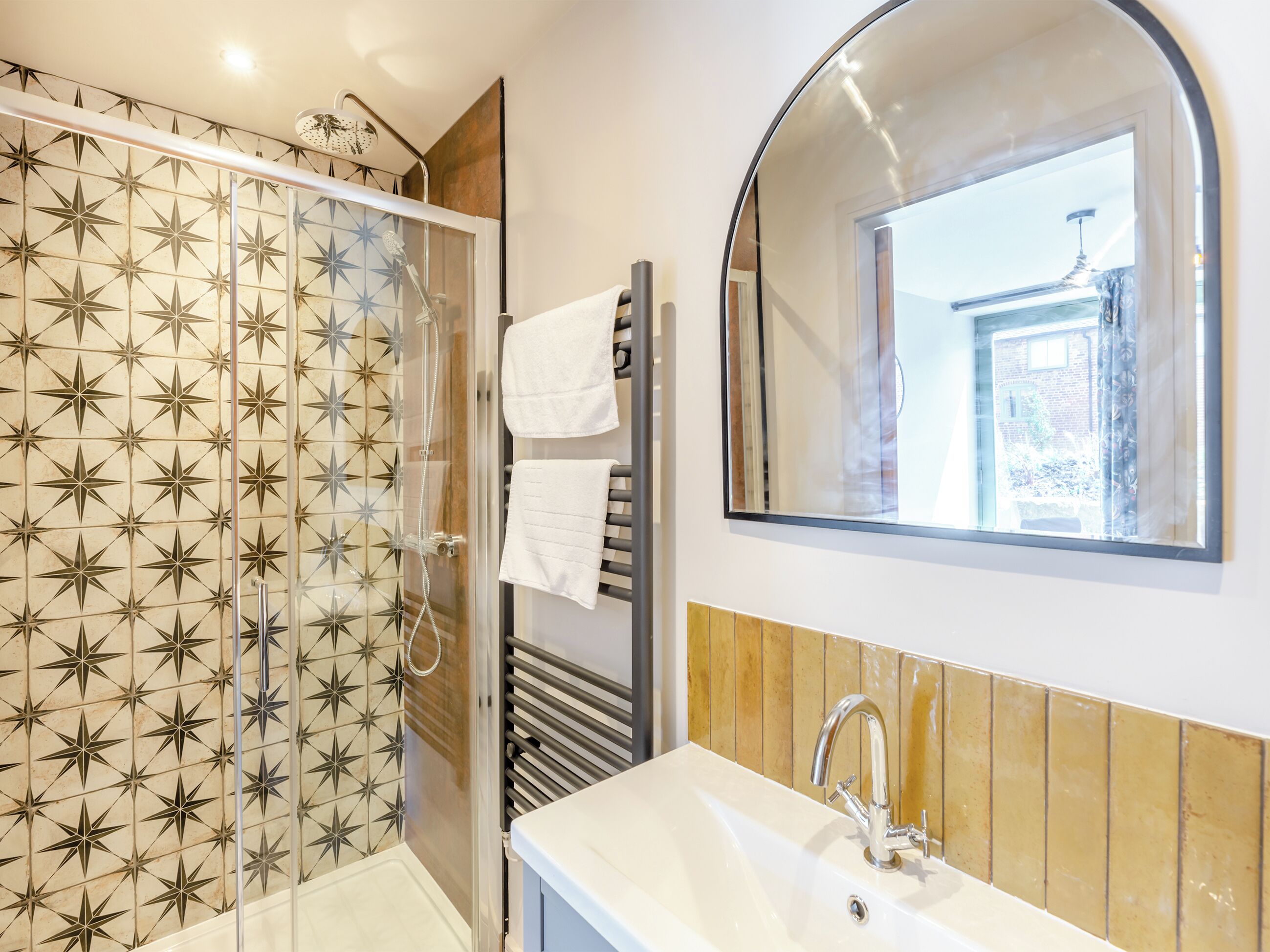 Une salle de bain avec une douche, un lavabo et un miroir.