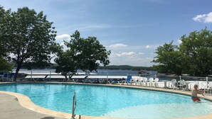 Ein Schwimmbad mit Liegestühlen und Blick aufs Wasser.