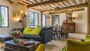 Una sala de estar acogedora con sofá, sillones, una mesita de centro y un comedor con mesa y sillas.
