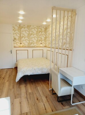 1 habitación, escritorio y tabla de planchar con plancha