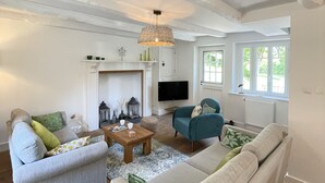 Una sala de estar con chimenea, sofá y televisión.