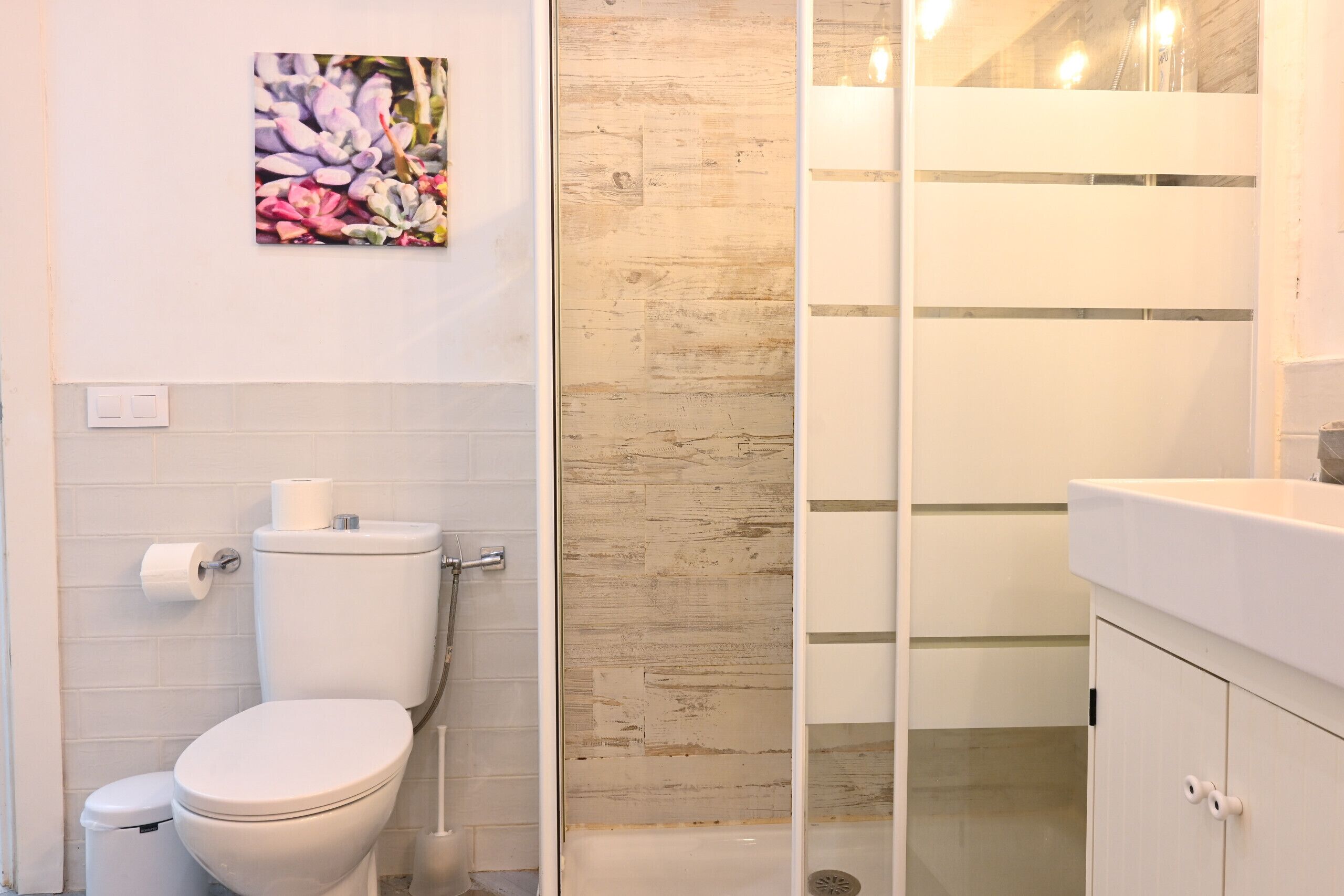 A bathroom with a toilet, a shower, and a sink.