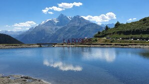 A serene lake with a mountain backdrop and the text "LA ROSAFIRE" visible on the shore. - Studio 4 Pers, vue Magnifique à 150 m des Pistes (Montvalezan)