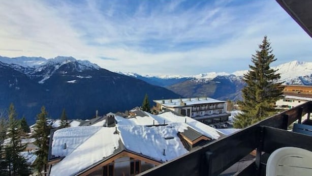 A mountain view with snow-covered roofs and buildings, including a wooden structure and a modern building with a sloped roof. - Studio 4 Pers, vue Magnifique à 150 m des Pistes (Montvalezan)