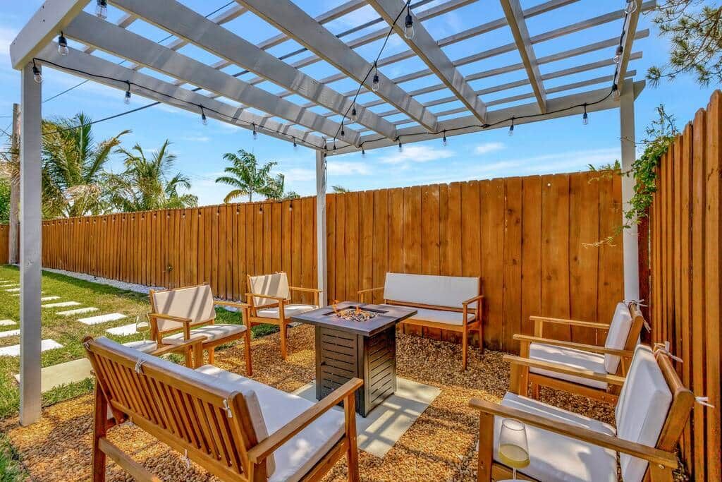 Un patio couvert avec des meubles en bois et un foyer.