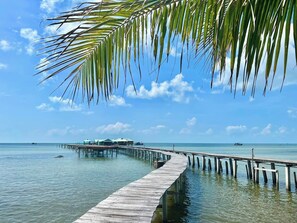 A wooden pier extending into calm waters with a clear sky. - Lotus Home (Phu Quoc)