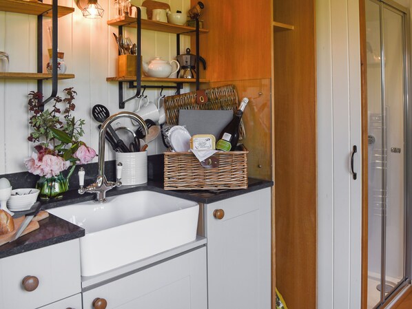 A kitchen with a sink, cabinets, and a wooden door.