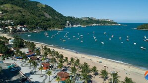 A coastal area with a beach, boats, and a hilly landscape. - Pousada Lisamar (Mangaratiba)