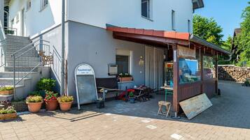 Een gebouw met een bord dat een restaurant aangeeft, buiten zitplaatsen en een trap naar de ingang.