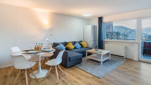 Un salon moderne comprenant un canapé, des fauteuils, une table basse et un coin repas.