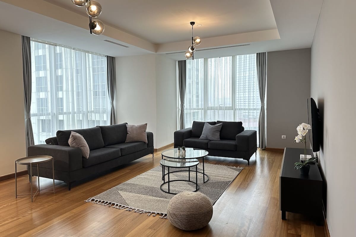 A modern living room with two sofas, a coffee table, and a TV stand.