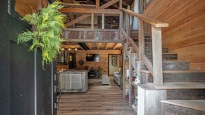 Un intérieur en bois comprenant un escalier, un coin cuisine et un espace salon.