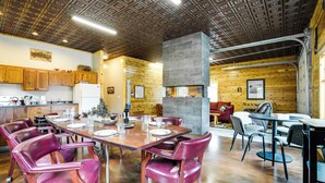 Une cuisine spacieuse avec des meubles en bois, un grand îlot central et un coin repas comprenant des chaises en cuir rouge et une table en bois.