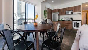 A modern kitchen with wooden cabinets, a built-in microwave, and a stainless steel refrigerator. - Doctores Apartments by VH (Mexico City)