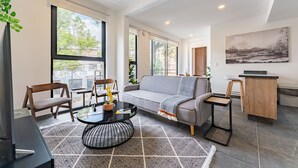 A modern living room with a sofa, chairs, a coffee table, and a small desk. - Doctores Apartments by VH (Mexico City)