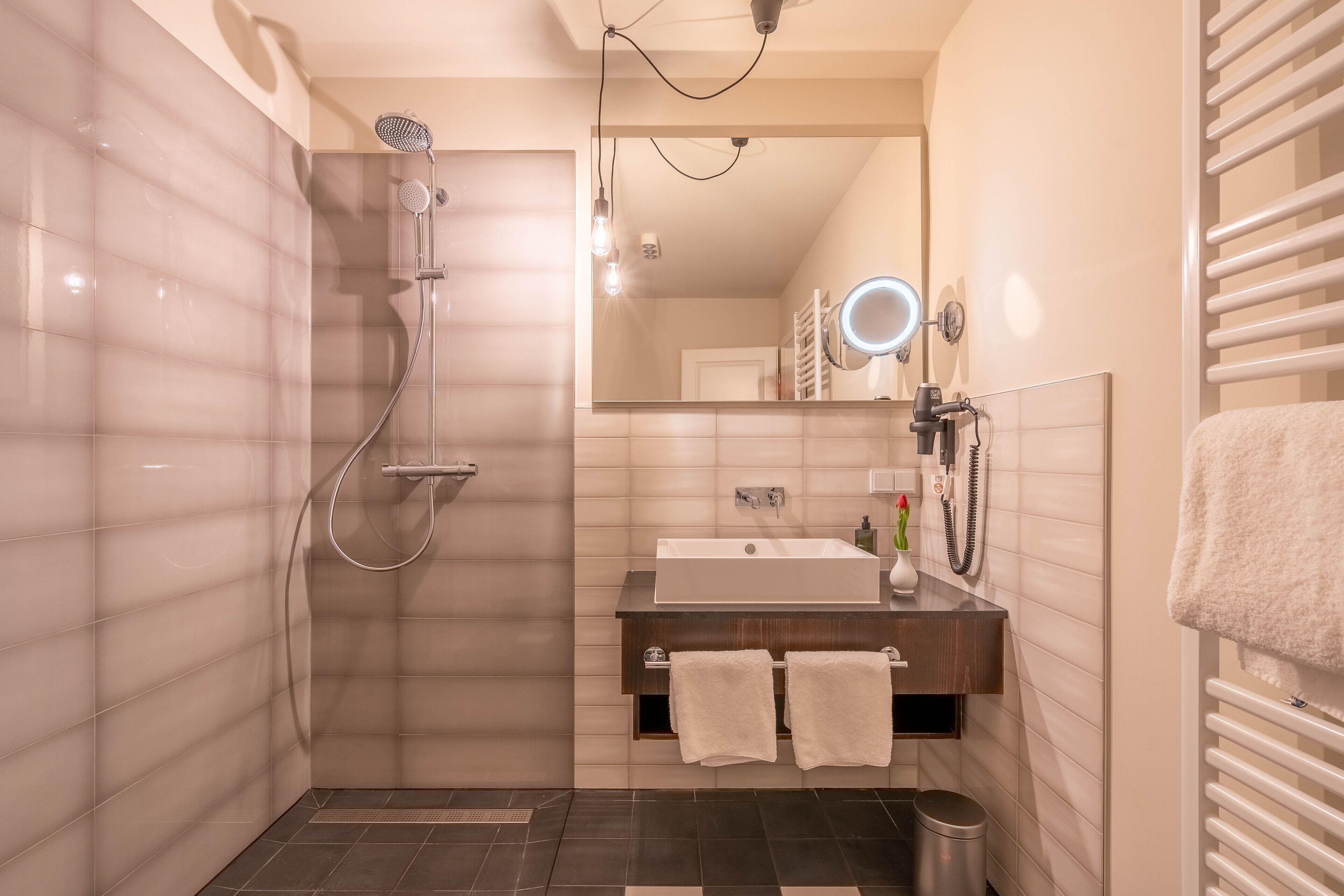 Ein modernes Badezimmer mit Dusche, Waschbecken und Waschtisch.