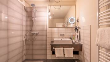 Ein modernes Badezimmer mit Dusche, Waschbecken und Waschtisch.