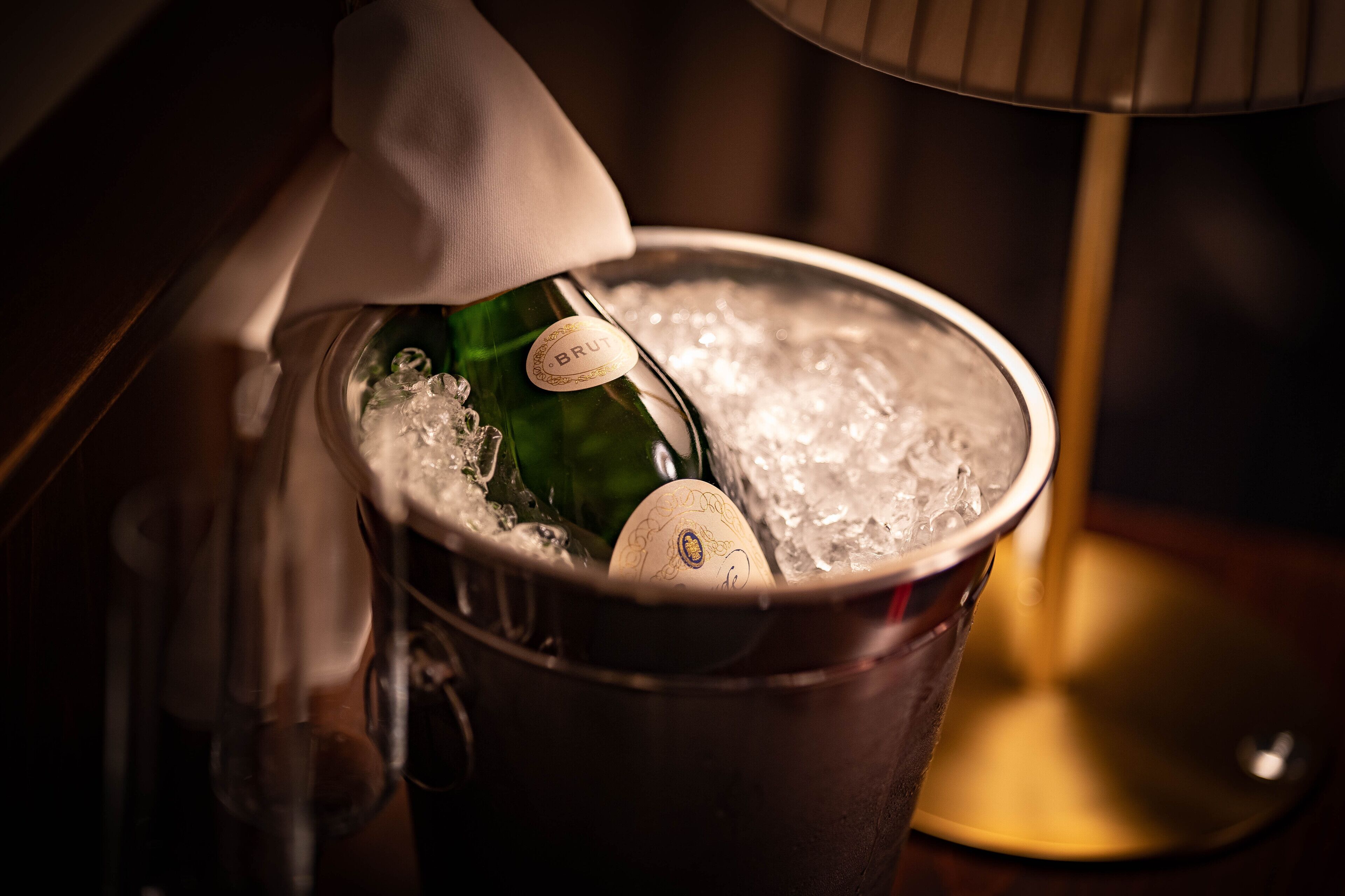 Eine Flasche Brut Champagner in einem Eiskübel mit einem Stoff.