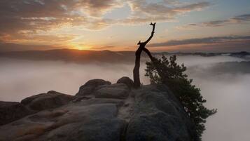 A rocky landscape with a silhouette of a person standing on a rock formation.