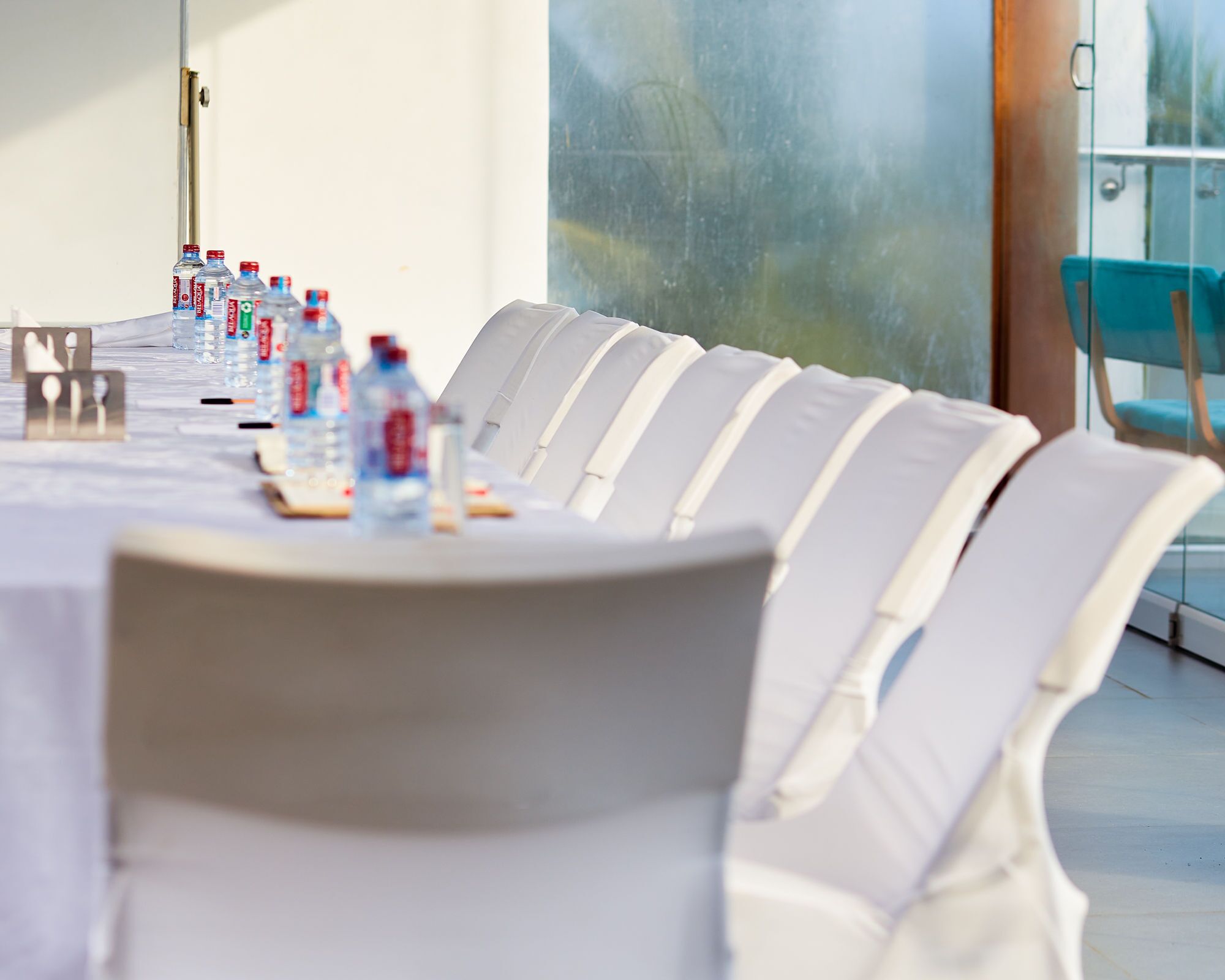 A conference room with a long table, chairs, and water bottles.