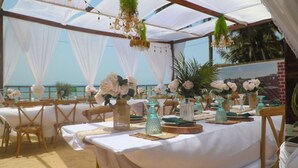 An outdoor dining area with white tablecloths, wooden chairs, and decorative vases. - La Villa Aphro Ghana (Kokrobite)